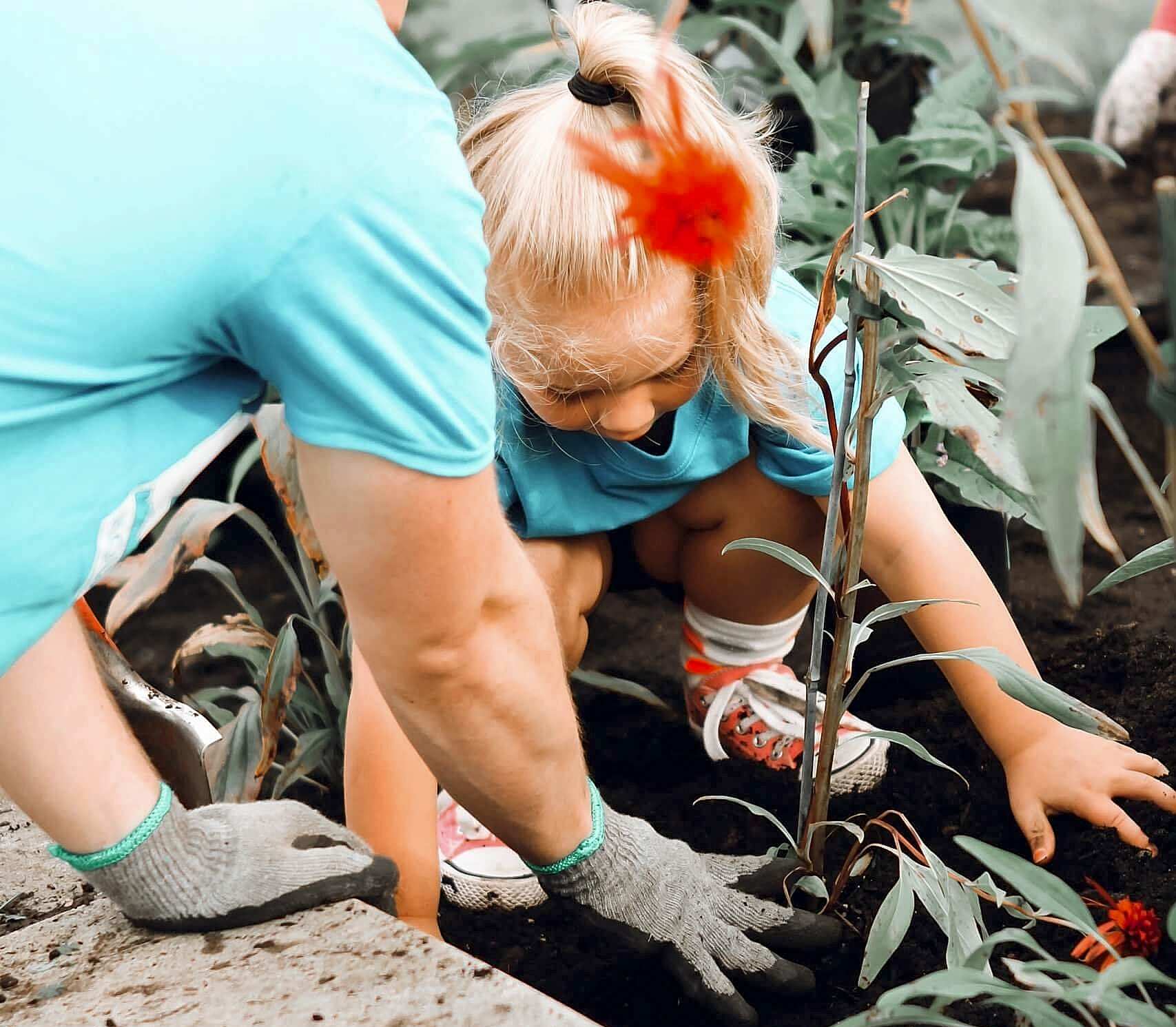 An adult and child are gardening together.